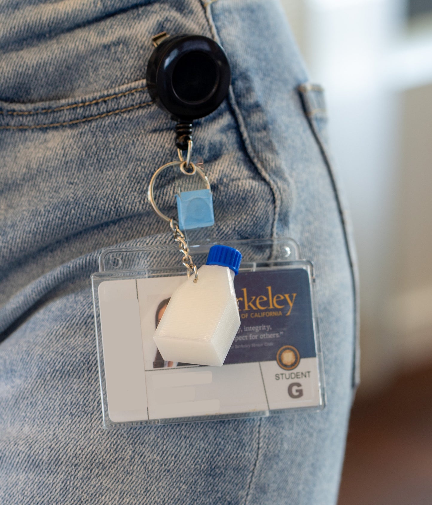 Retractable badge holder and ID with a miniature culture flask keychain with a blue cap